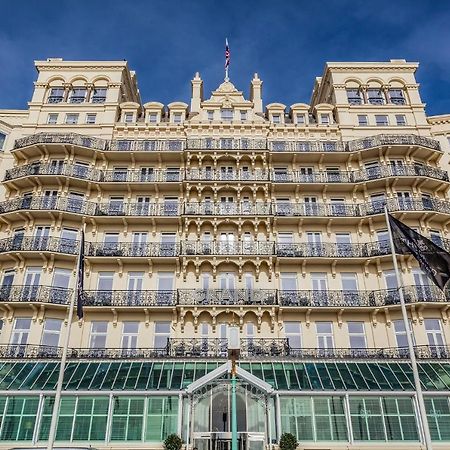 Hotel The Grand Hove Esterno foto The photo shows a grand, multi-story building with a distinctive architectural style. The facade features a pale yellow color, ornate decorative elements, and numerous balconies adorned with intricate railings. There are large windows allowing ample 