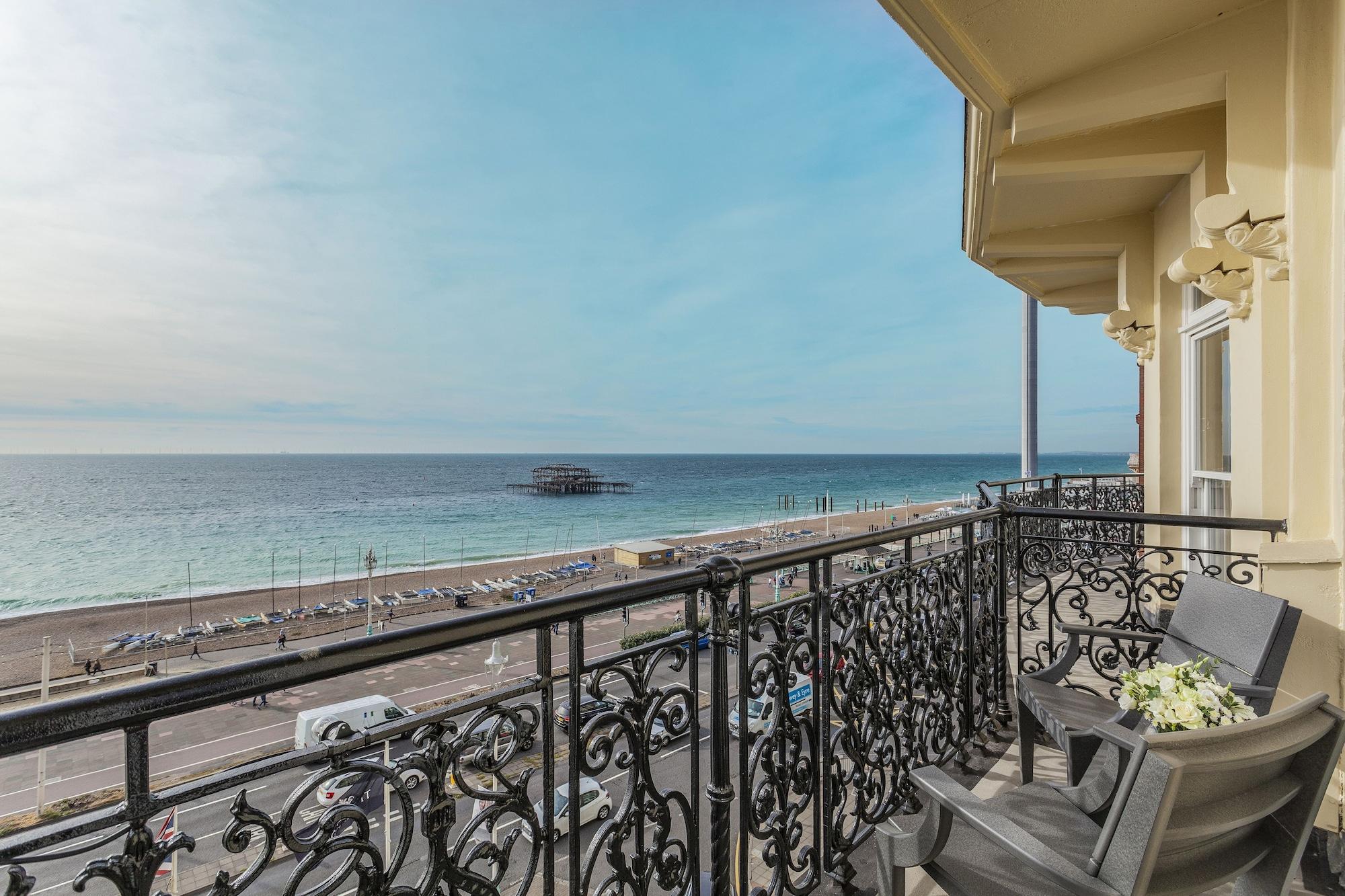 Hotel The Grand Hove Esterno foto The photo shows a view from a balcony overlooking a beach. The scene features a calm sea with gentle waves, extending towards the horizon under a largely clear sky. In the foreground, the balcony has an ornate railing and a couple of chairs, suggesti