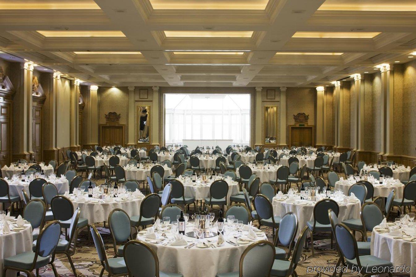 Hotel The Grand Hove Esterno foto The photo depicts a large banquet hall set up for dining. The space features several round tables, each covered with white tablecloths and adorned with plates, glasses, and cutlery, indicating a formal arrangement for a meal or event. The chairs surr