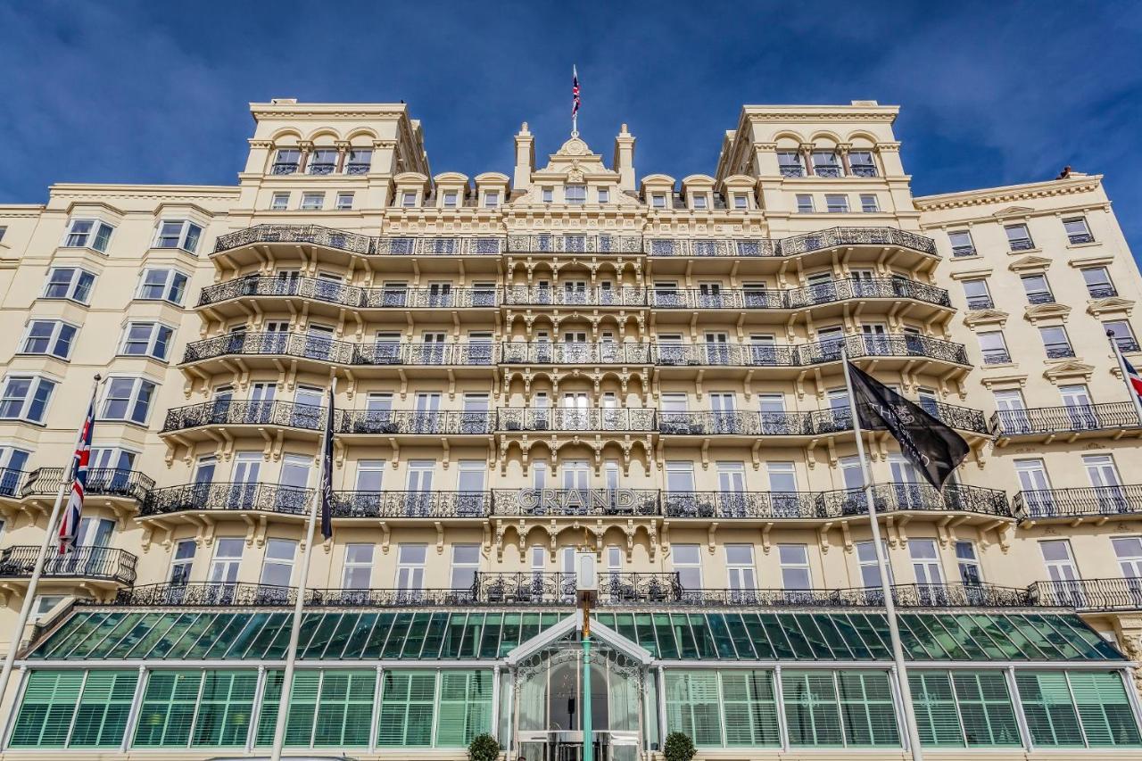 Hotel The Grand Hove Esterno foto The photo shows a grand, multi-story building with a distinctive architectural style. The facade features a pale yellow color, ornate decorative elements, and numerous balconies adorned with intricate railings. There are large windows allowing ample 